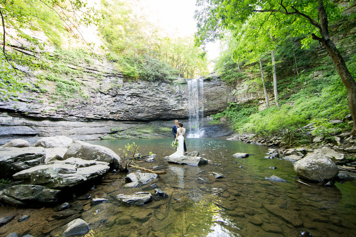 Waterfall backdrop for wedding vows.  Photo by destination elopement photographer Rebecca Cerasani