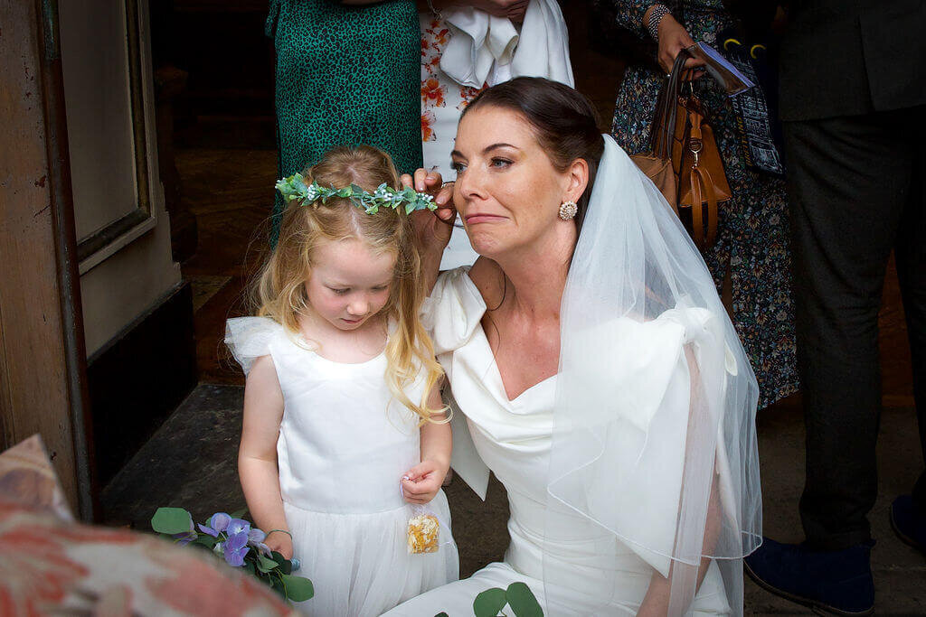 Bride making funny face next to grumpy flowergirl