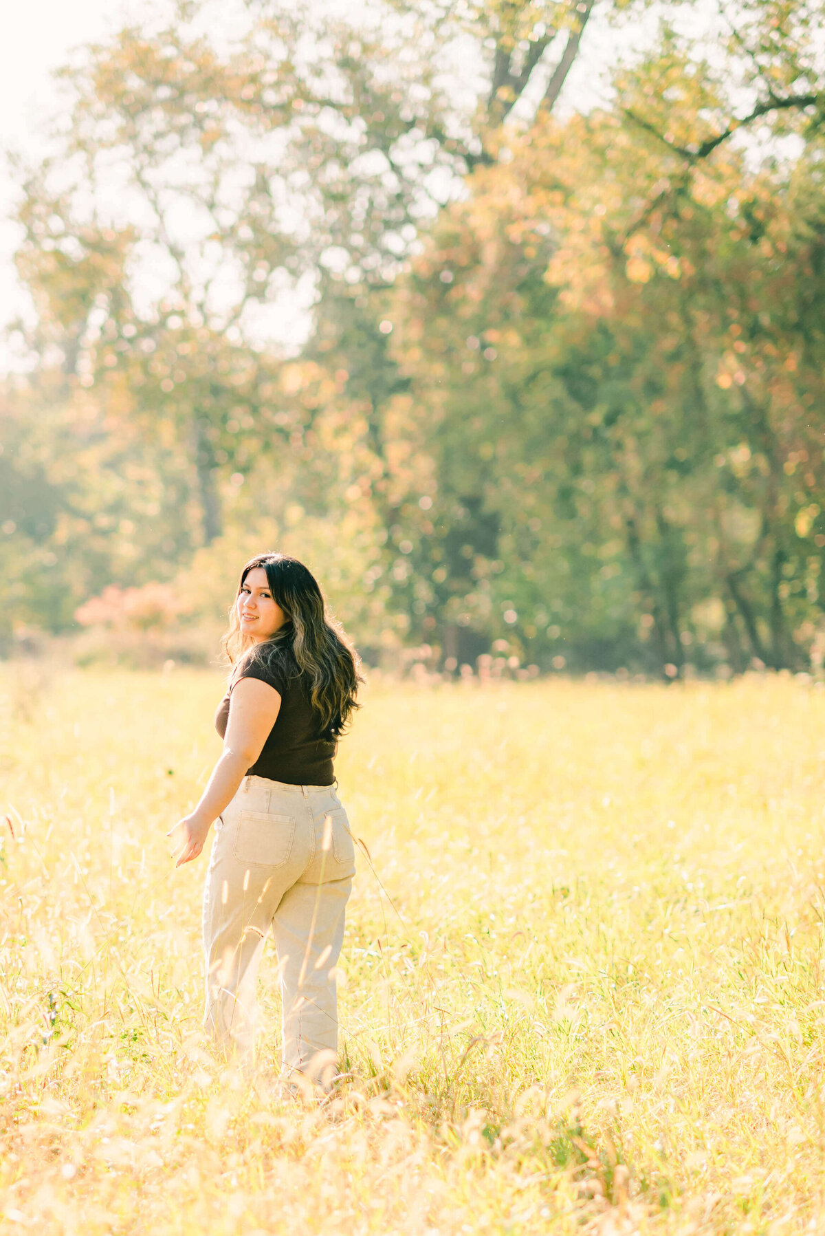 Latina senior walking in a field of yellow grass