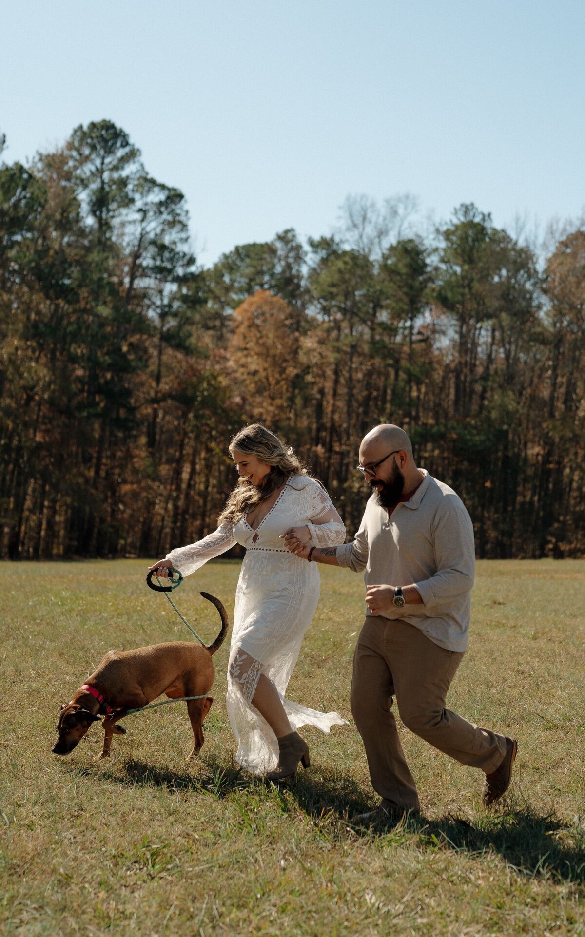 Couple walking a dog in a field
