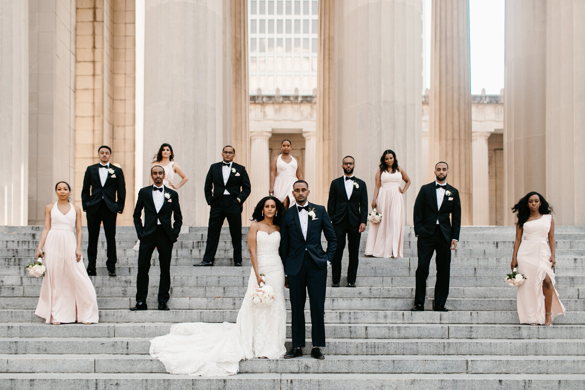 bride and groom with bridal party posing on stairs