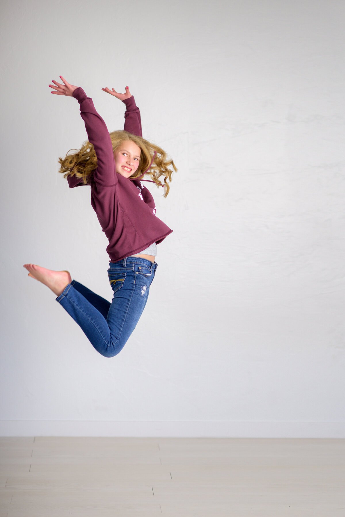 Tween girl jumping in photo studio in Boise.