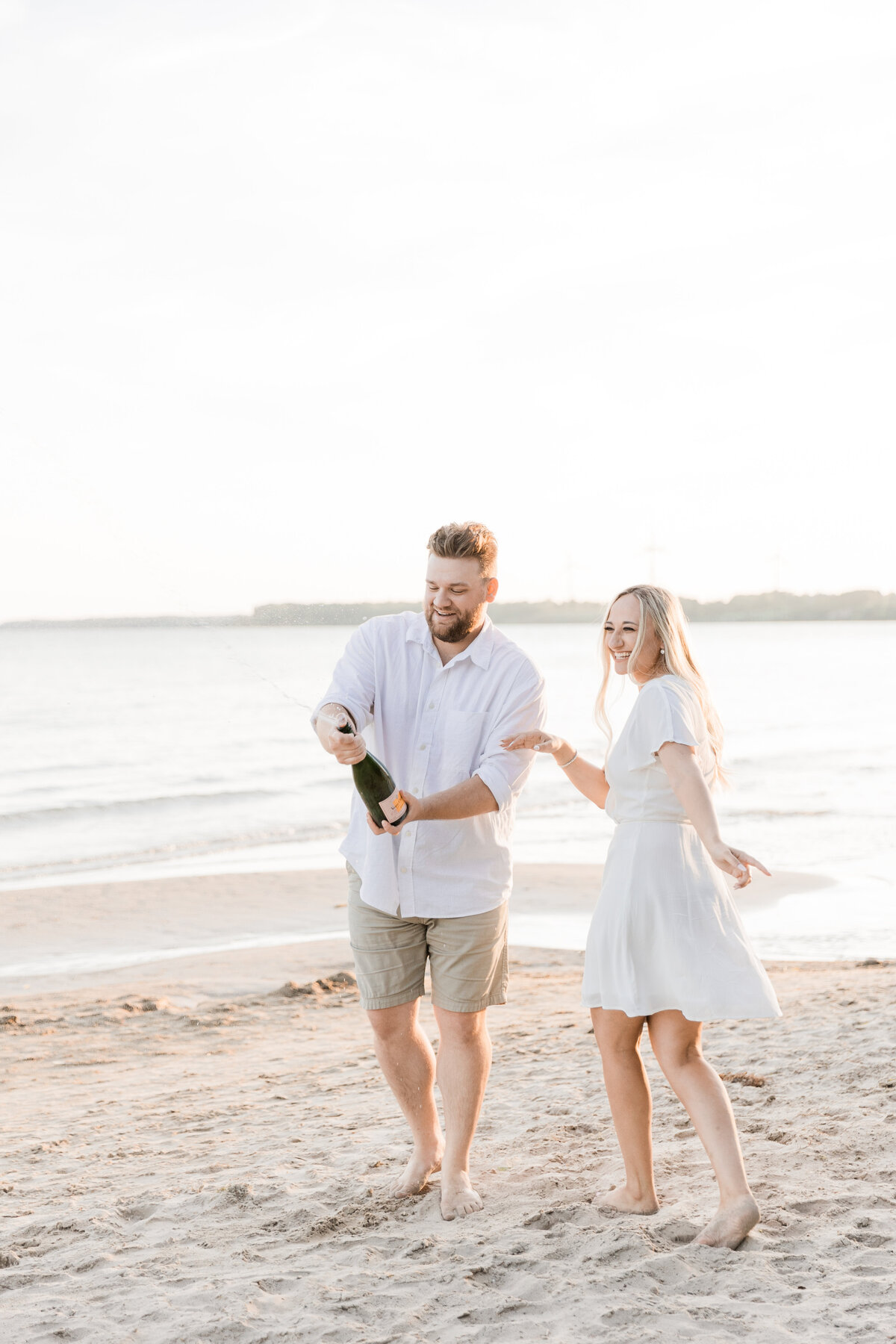 Couple popping champaign on a beach