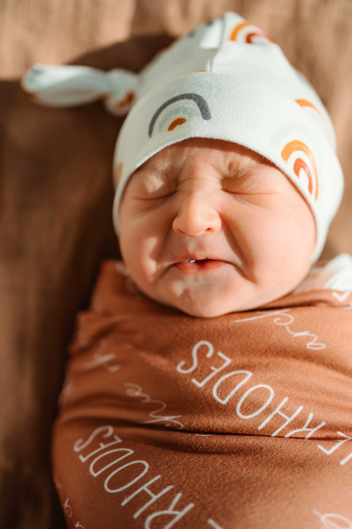 A heartfelt image of a newborn baby crying, wrapped snugly in a soft brown blanket. This touching moment was captured by a top photographer in Albuquerque