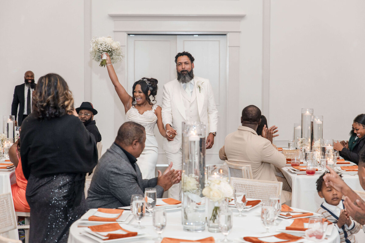 Laughter fills the room as the couple feeds each other cake during their reception.