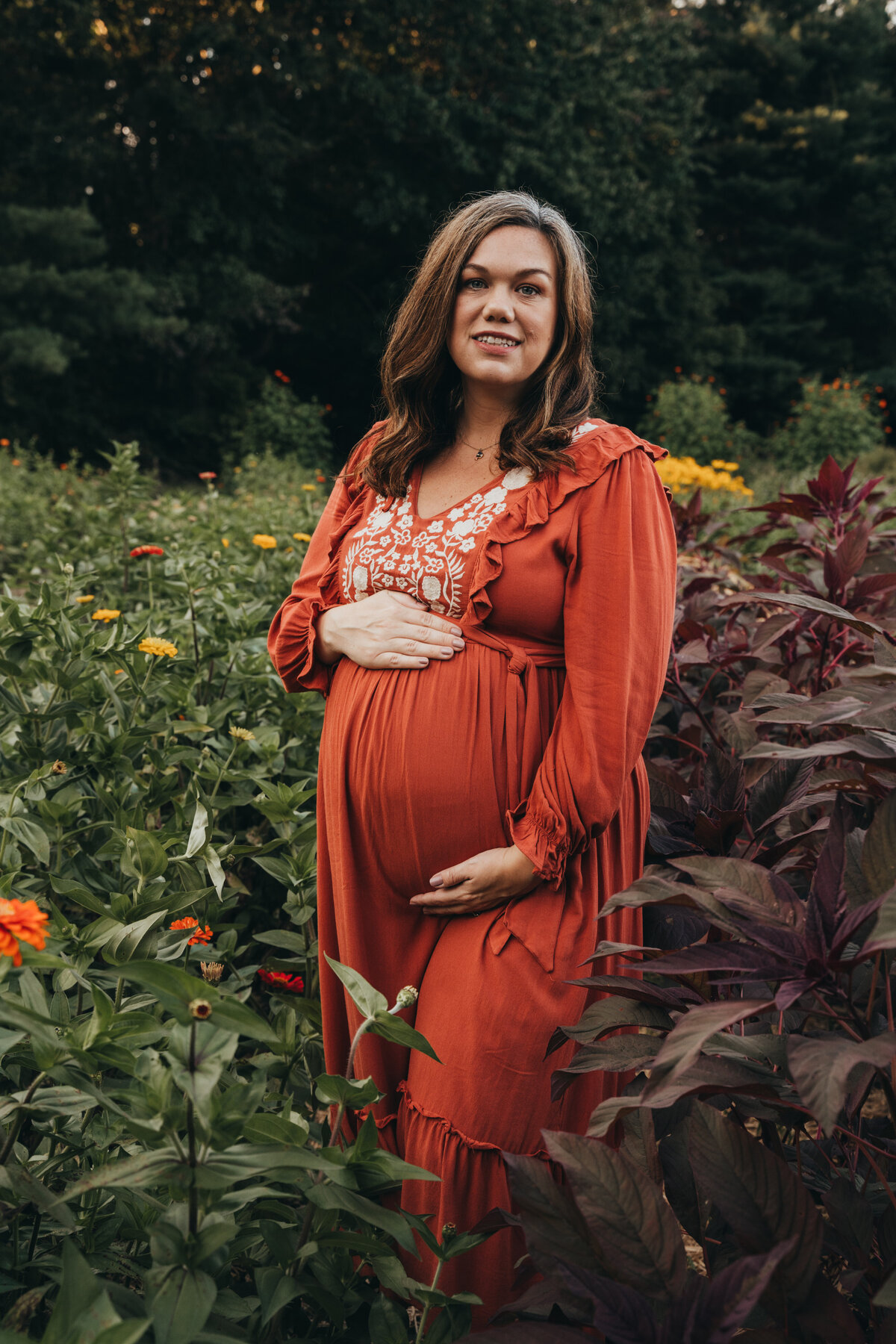 woman holding her belly in flower field