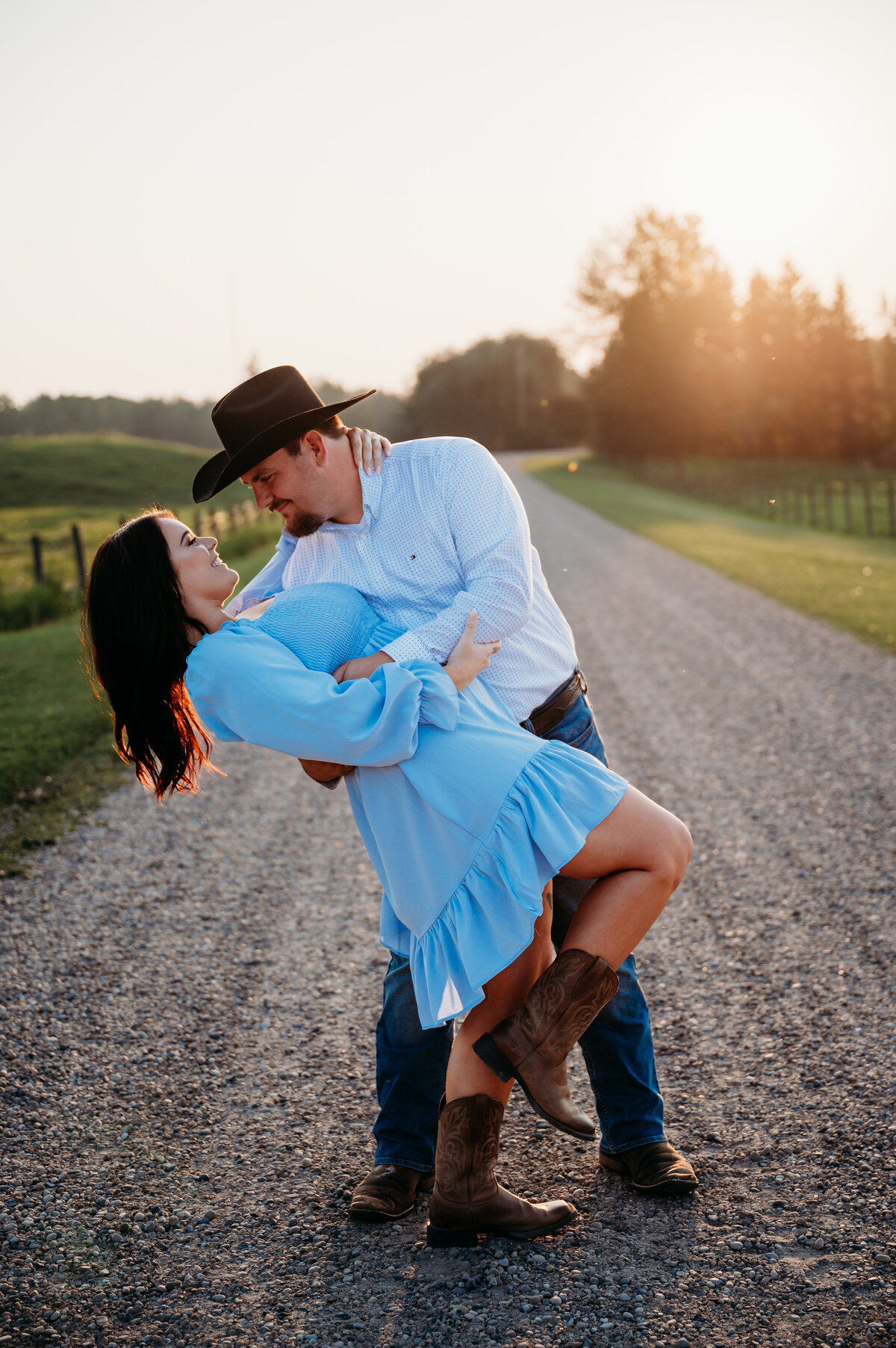couple standing on dirt road in Edmonton, Alberta posing for their engagement photography session