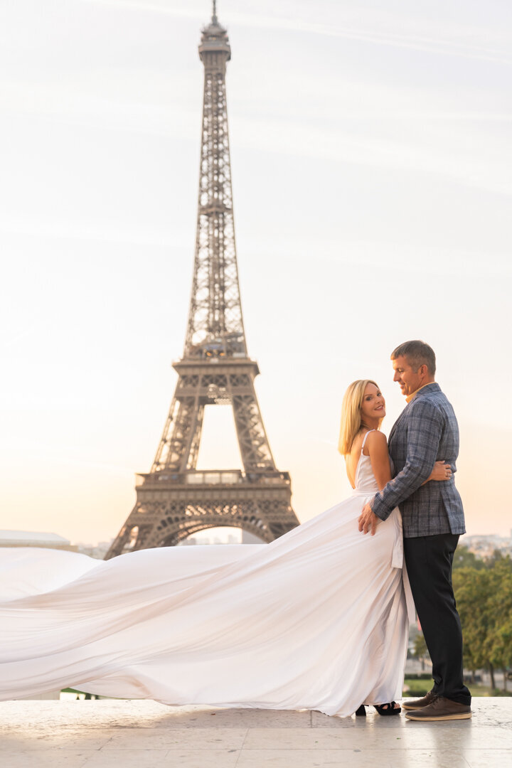 Elegant couple photoshoot Paris, white flying dress, Eiffel Tower backdrop, professional photography