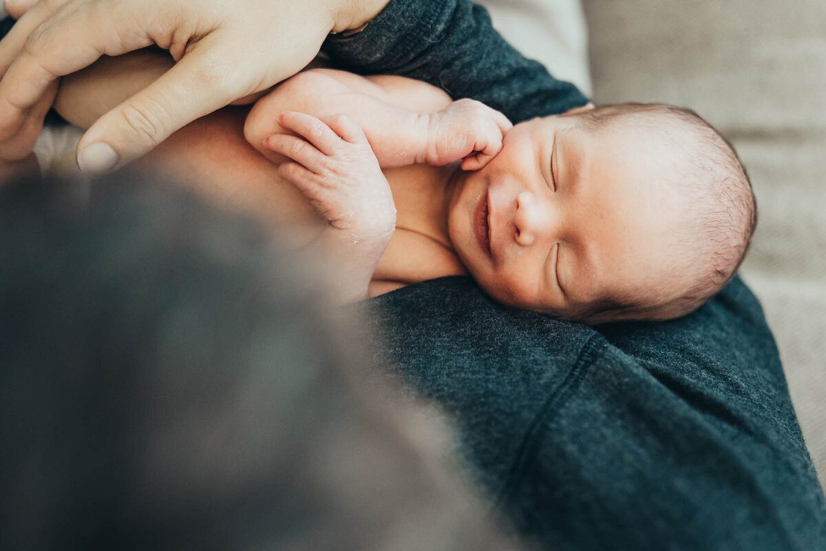 A dad holds his newborn baby during his In-home lifestyle photography session in his San DIego home