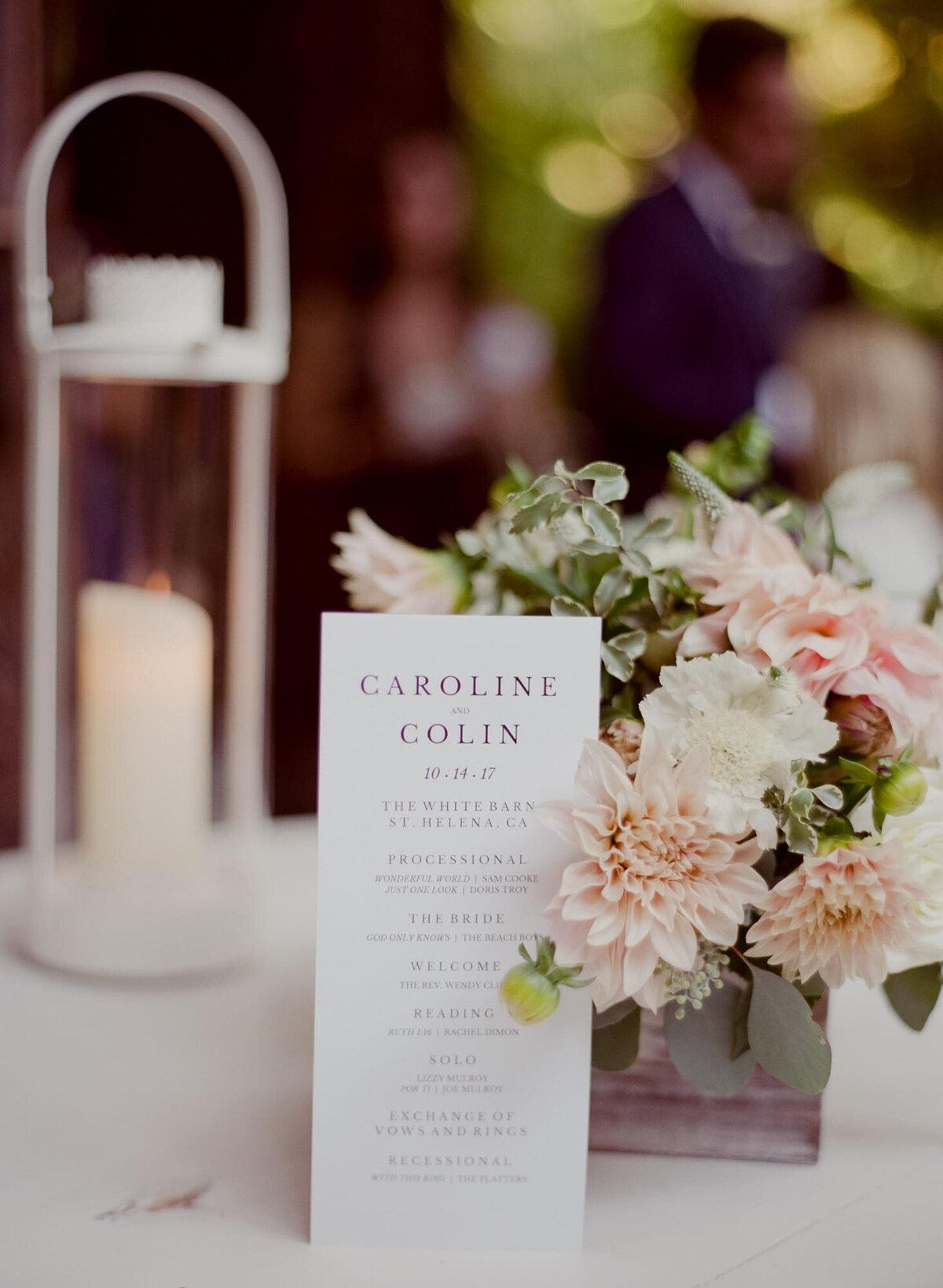 Beautiful and minimally designed wedding card placed alongside a colorful flower bouquet.