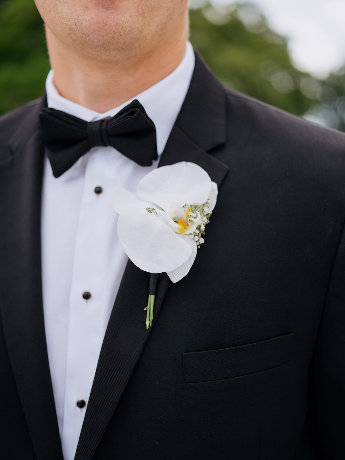 Black tux with orchid boutonniere for the groom