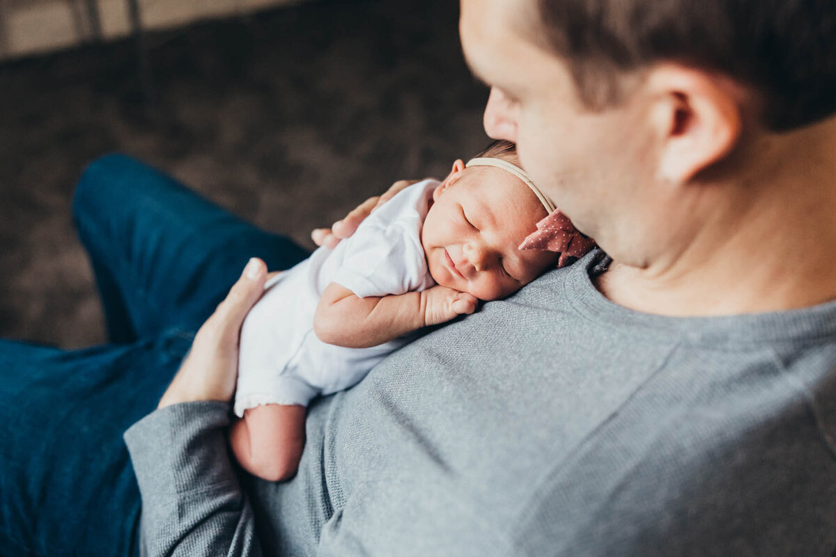 a dad holds his newborn baby against his chest in their allied gardens home in san diego