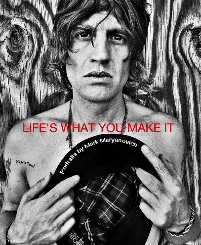 Book Cover title Lifes What You Make It Musician Nico Stai standing against wood wall shirtless with hat in his hands against his chest black and white
