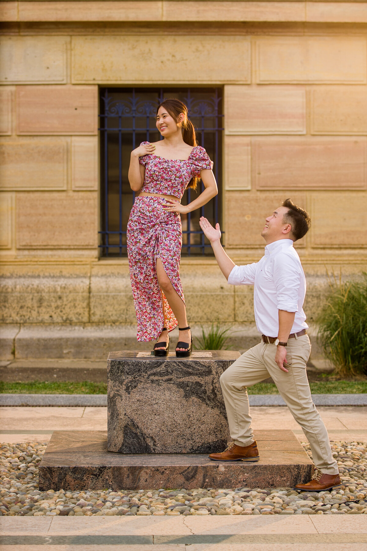 An engaged couple playfully posing like statues during a quirky engagement session at an art museum, capturing their creativity and sense of humor against a backdrop of artistic and cultural charm.