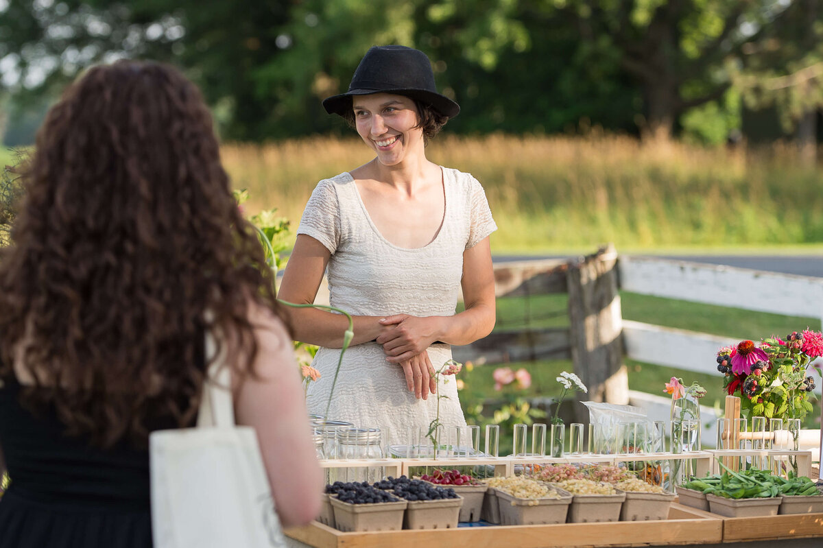 Ottawa event photos showing a market vendor interacting with a guest at Soiree in the Field.  Captured by JEMMAN Photography COMMERCIAL