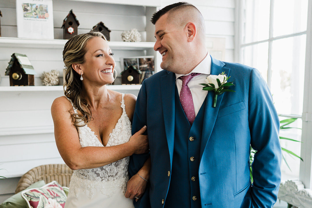 bride-and-groom-smiling-holding-arms-indoor-wedding-photo-nj