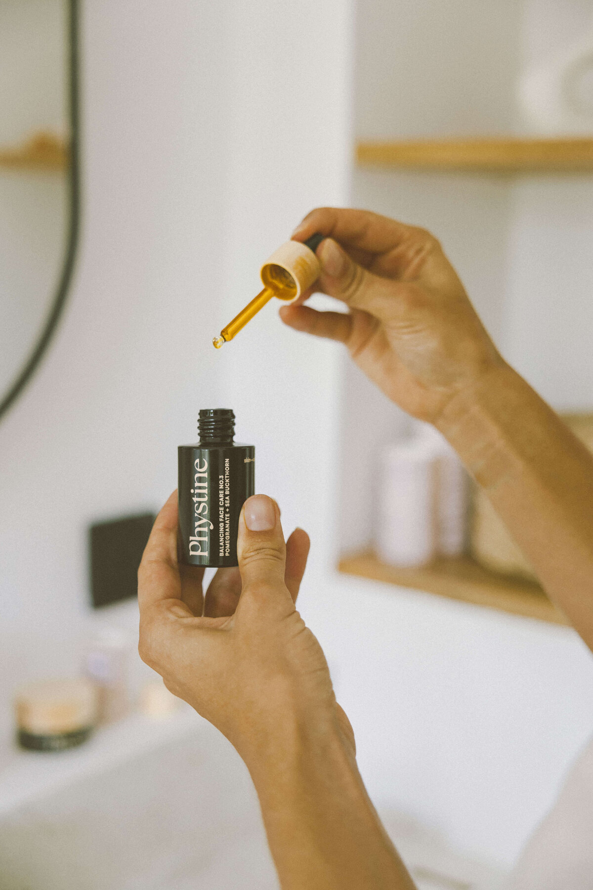 Skin care brand photography of model applying facial serum with dropper