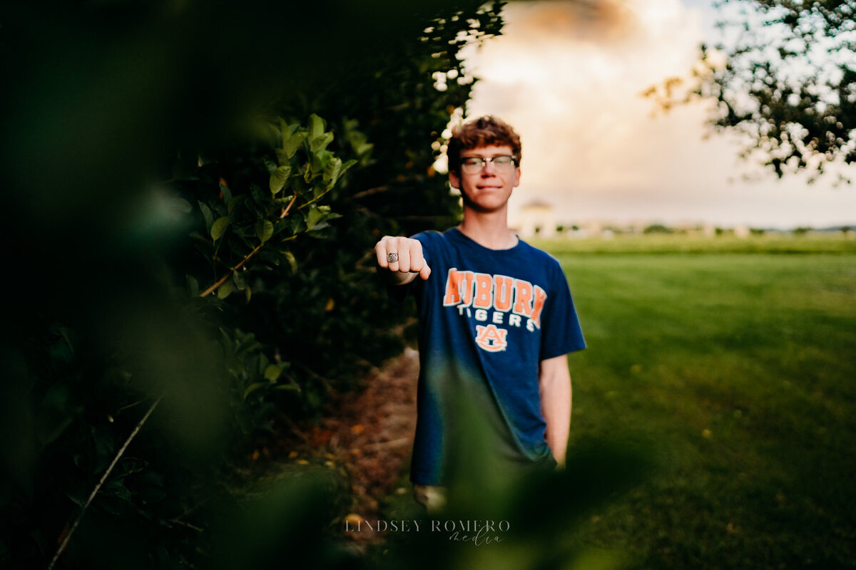 guy showing off graduation ring for senior photos in Youngsville, la