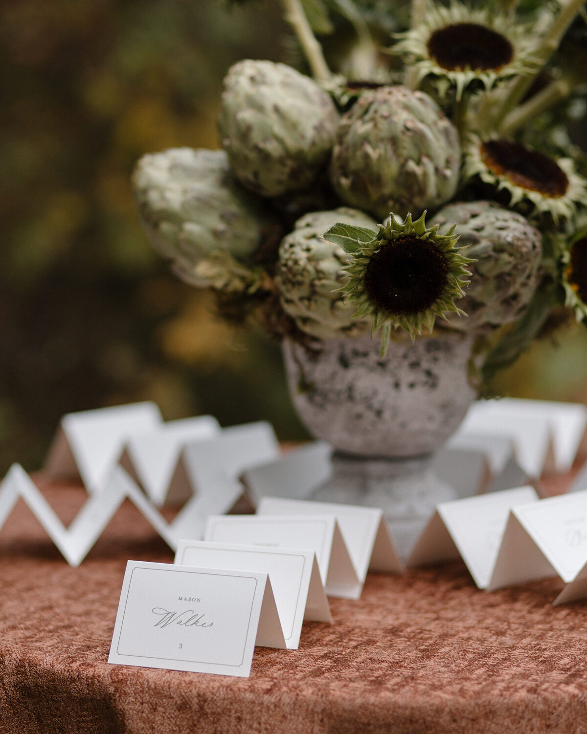 Tented Wedding Escort Cards on Table with Artichokes and Sunflowers