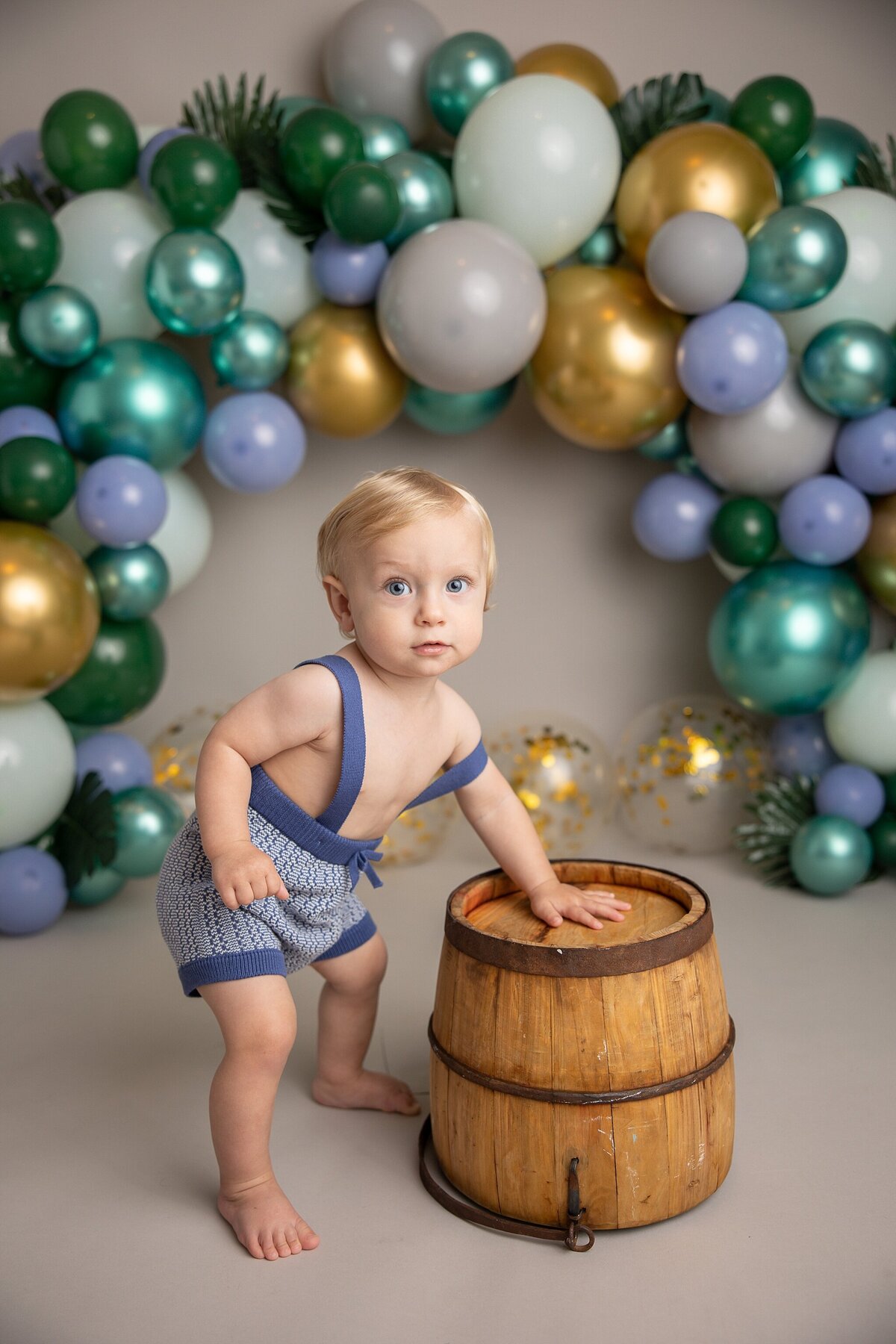 baby boy standing up on bucket for first birthday pictures