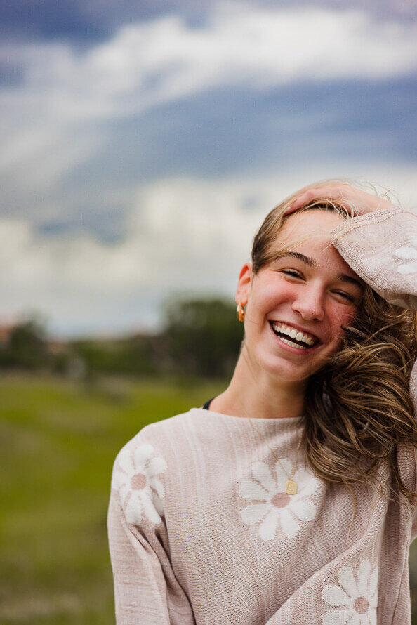 Girl laughs and fixes hair.
