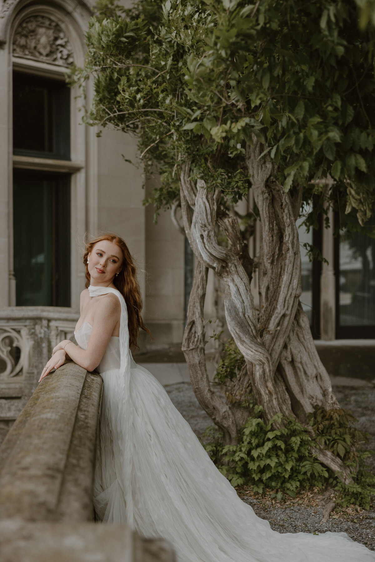 Bride exuding effortless elegance in a minimalist Watters gown on the terrace of the Biltmore Estate.