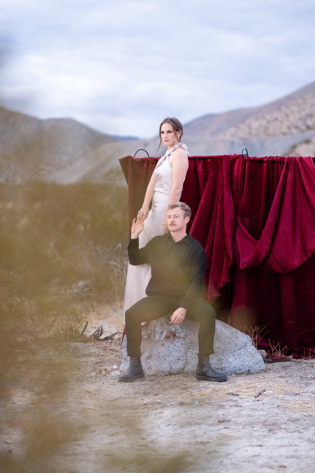 Editorial portrait of couple in desert at golden hour holding each others hands