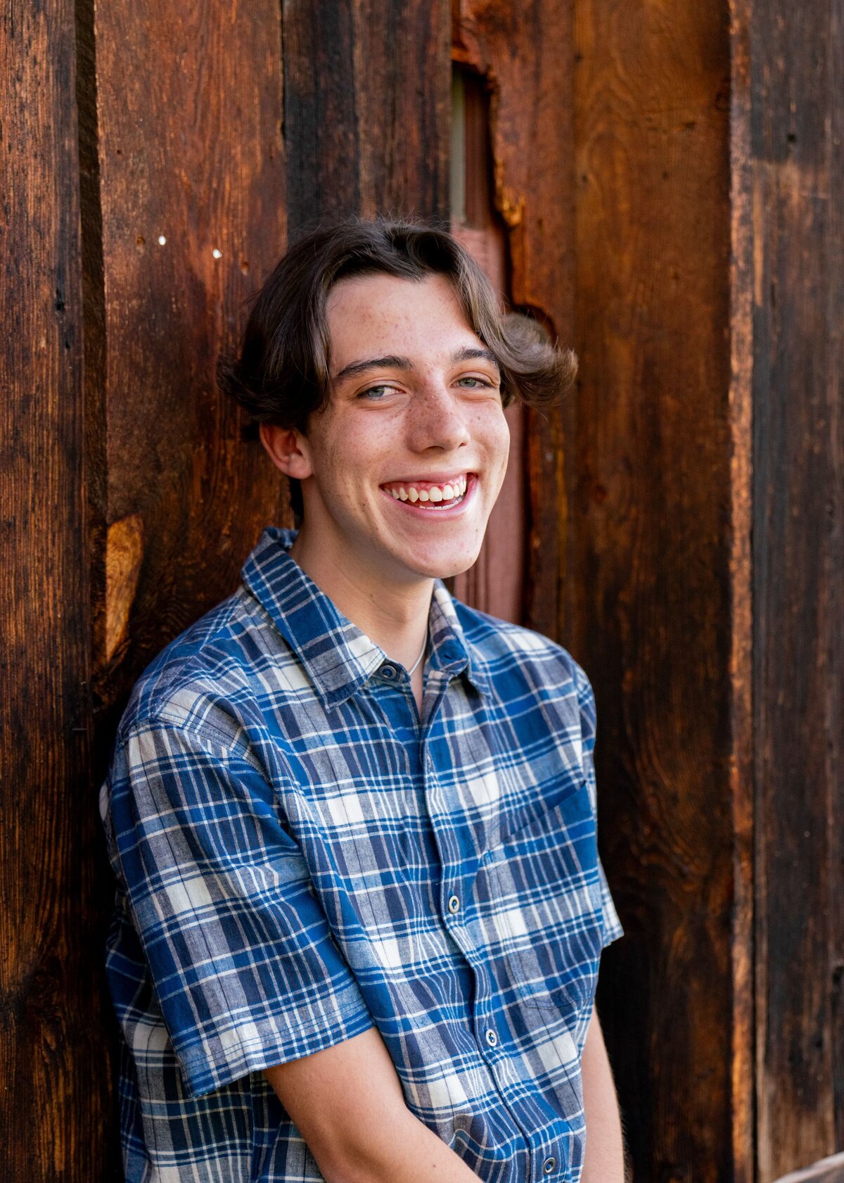 boy smiling in blue plaid shirt