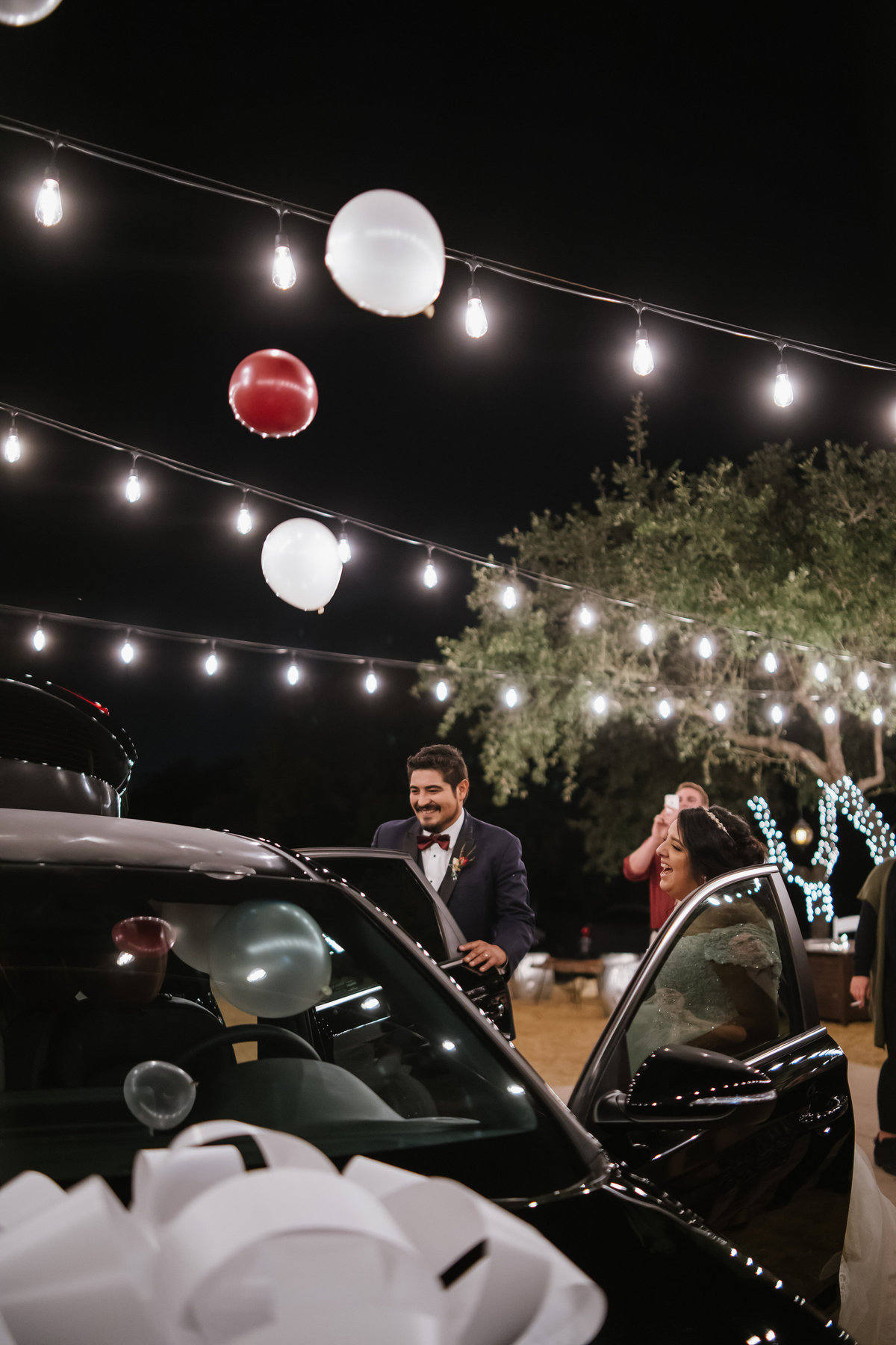 bride and groom open surprise car wedding gift at reception at Oaks at Heavenly Wedding venue in Helotes