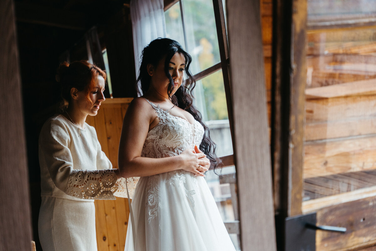 Bride getting ready inside rustic cabin before ceremony