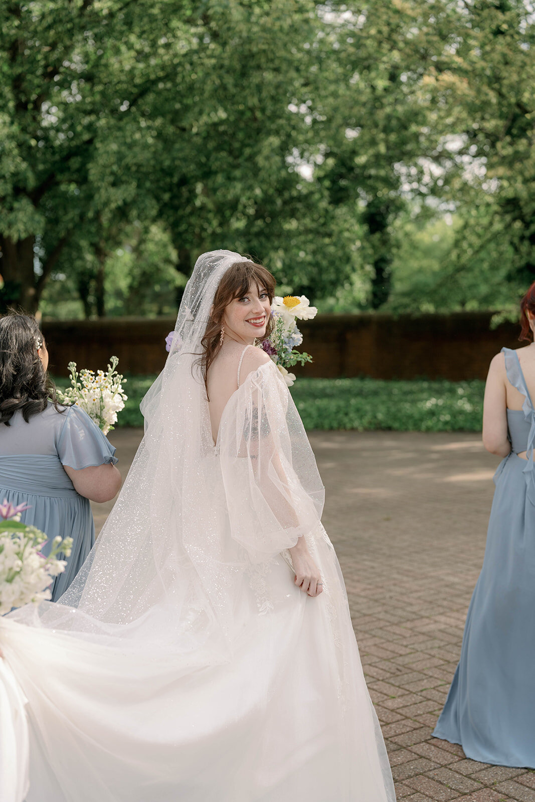Bride looking over shoulder in natural light outdoor portrait in Michigan