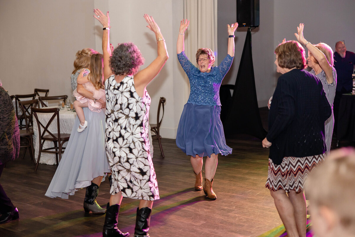 women dance to YMCA at wedding reception