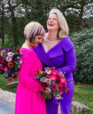 Two brides laughing for their wedding pictures