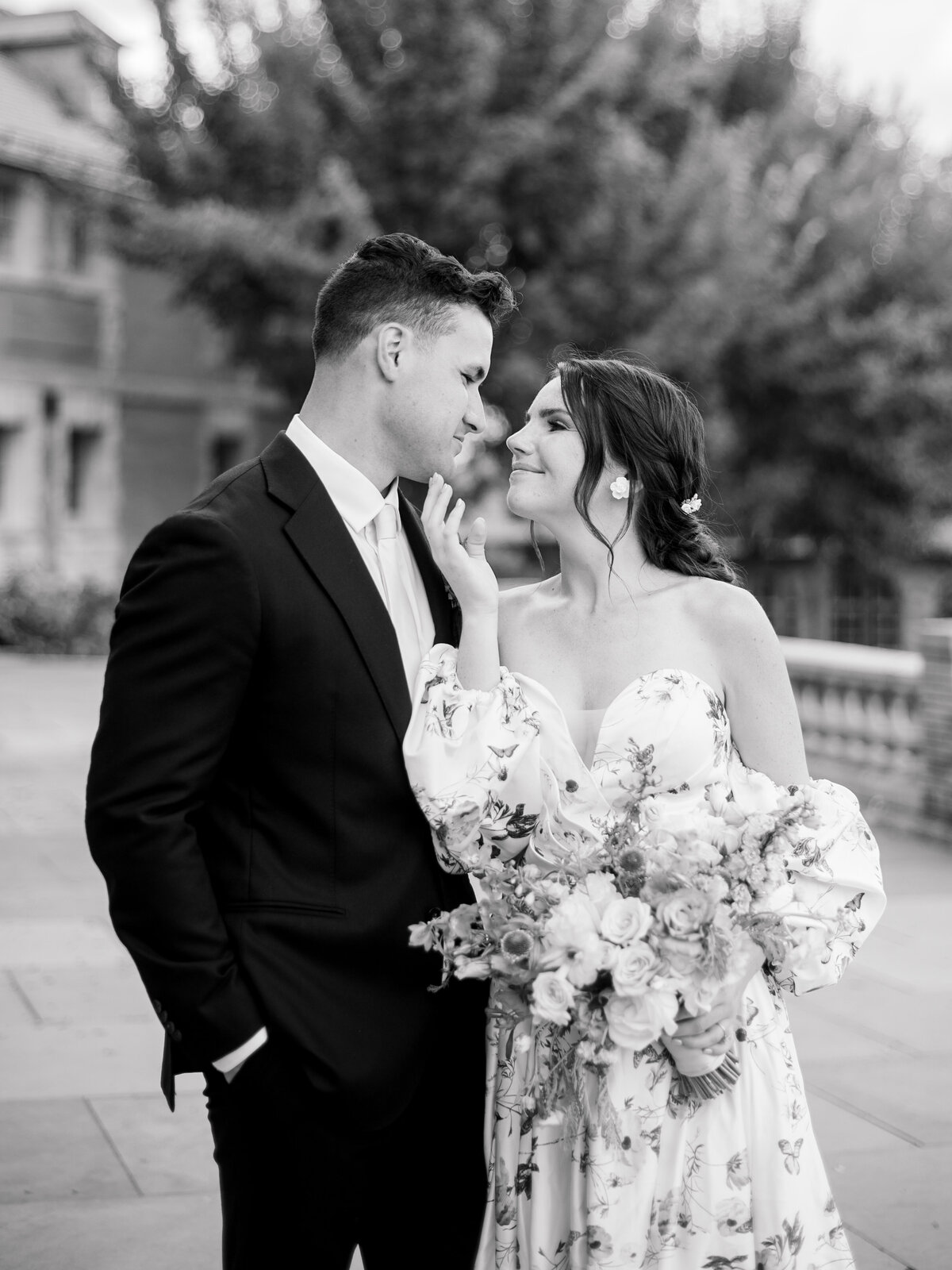 Bride in floral gown holding a garden-style bouquet, sharing an intimate moment with groom at Cairnwood Estate, photographed by Philadelphia fine art wedding photographer Elizabeth Kane.