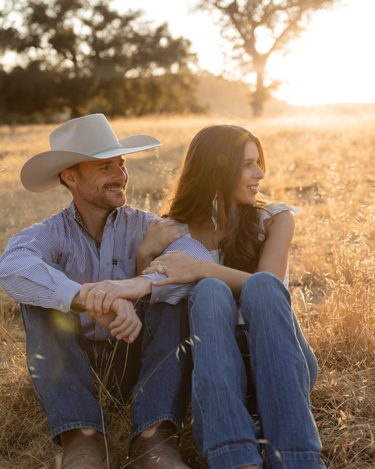 candid couples engagement photos in open field during golden hours in San Luis Obispo