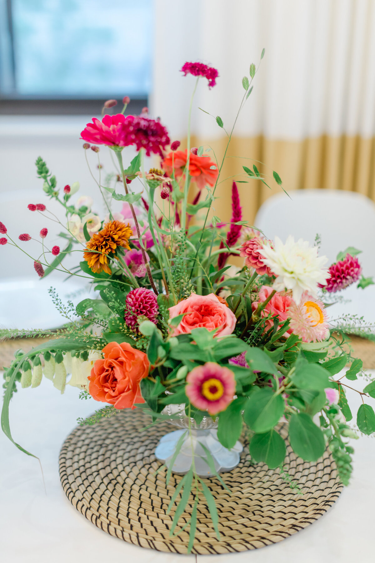 An arrangement of bright pink and orange flowers in lush greenery for a Montreal wedding.