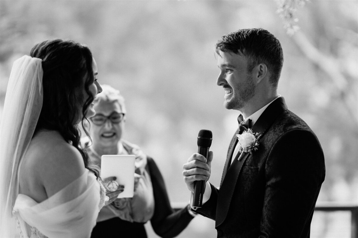 A couple stands lovingly at their ceremony, exchanging vows with heartfelt emotion.