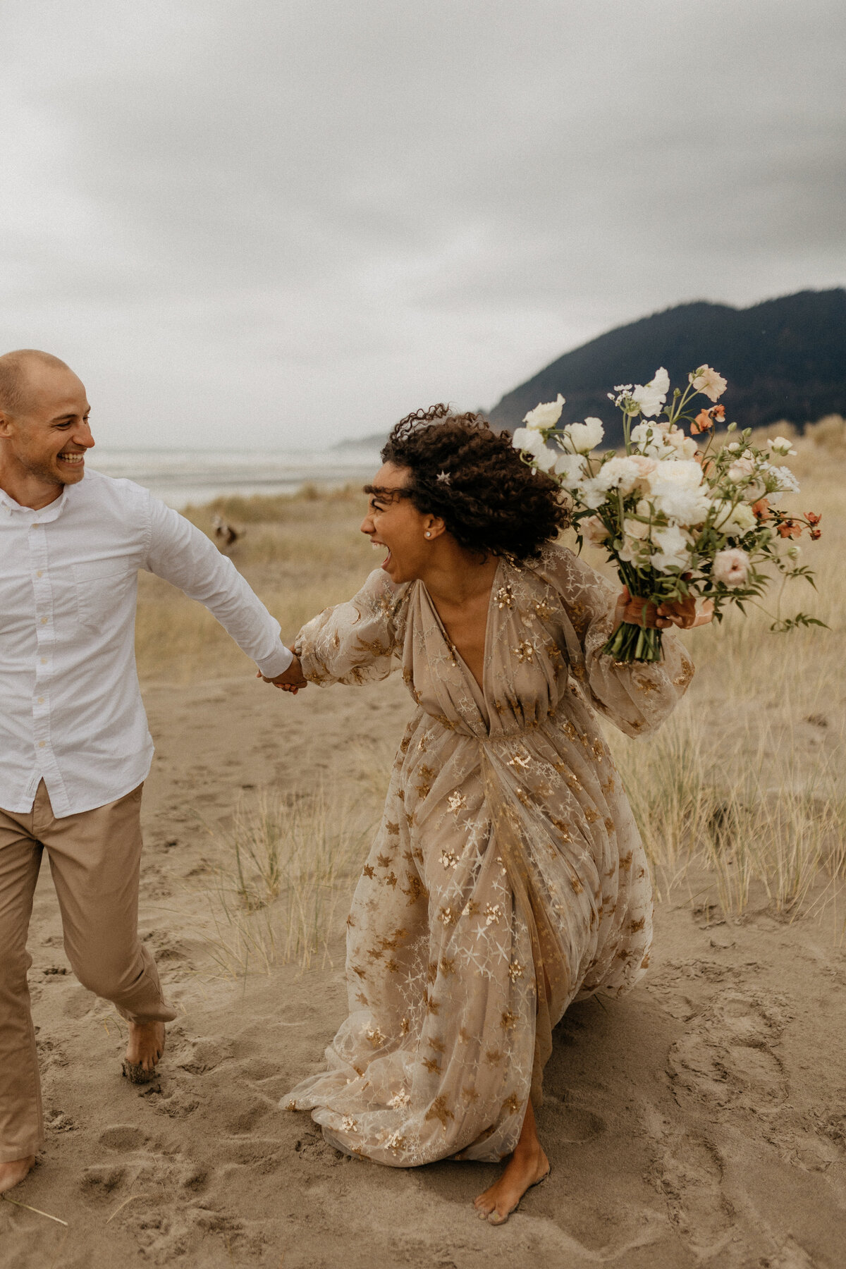 bride and groom running on beach