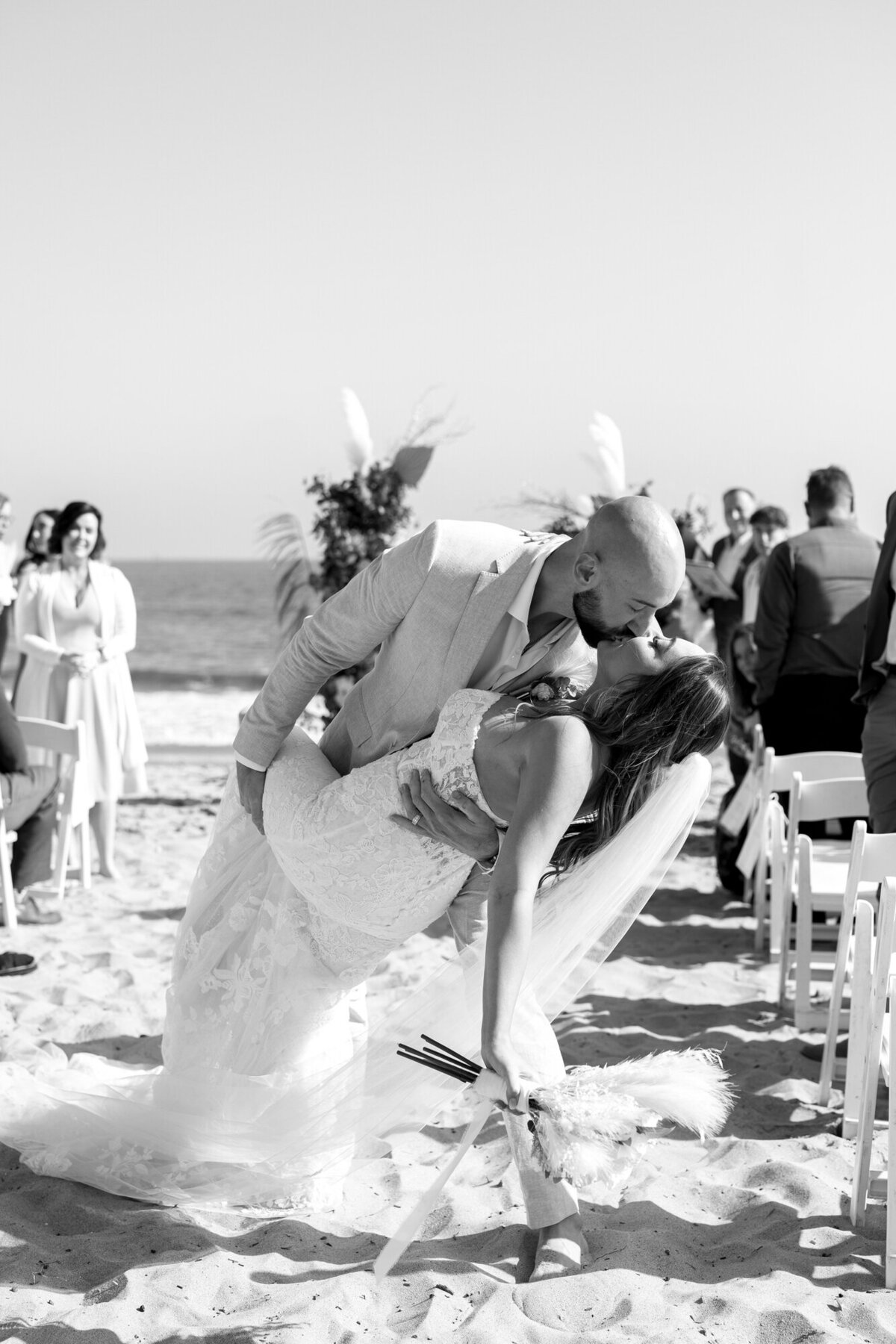 Bride and groom dip kissing exiting wedding ceremony at Hilton Beachfront Resort Santa Barbara