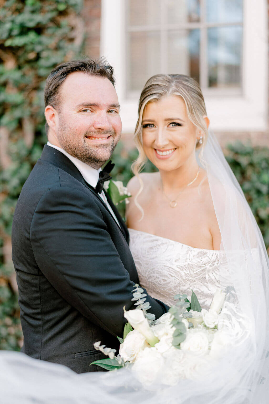 Close up portrait of bride and groom smiling at the camera captured by Rachael Mattio