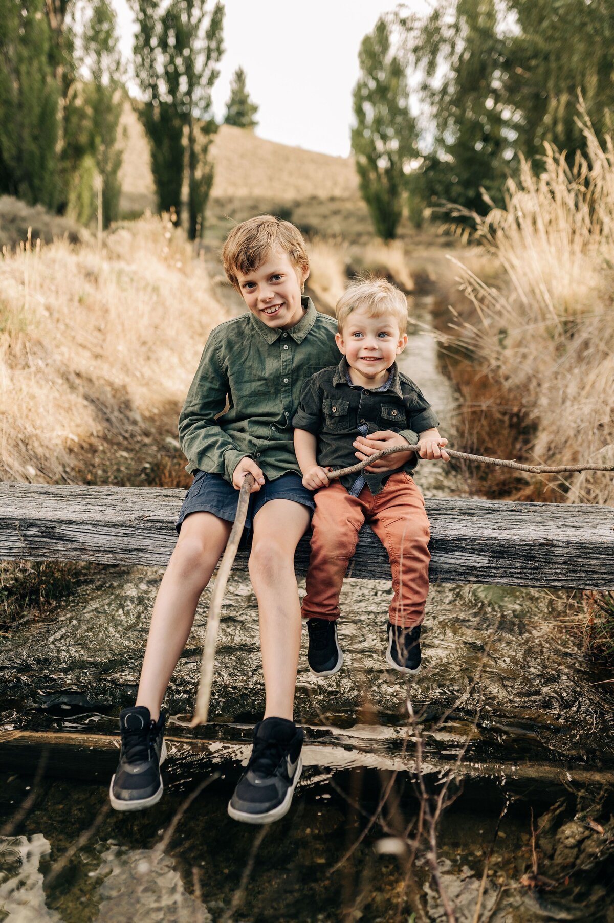 two boys brothers fishing family alexandra central otago new zealand sunset dry grass portraits