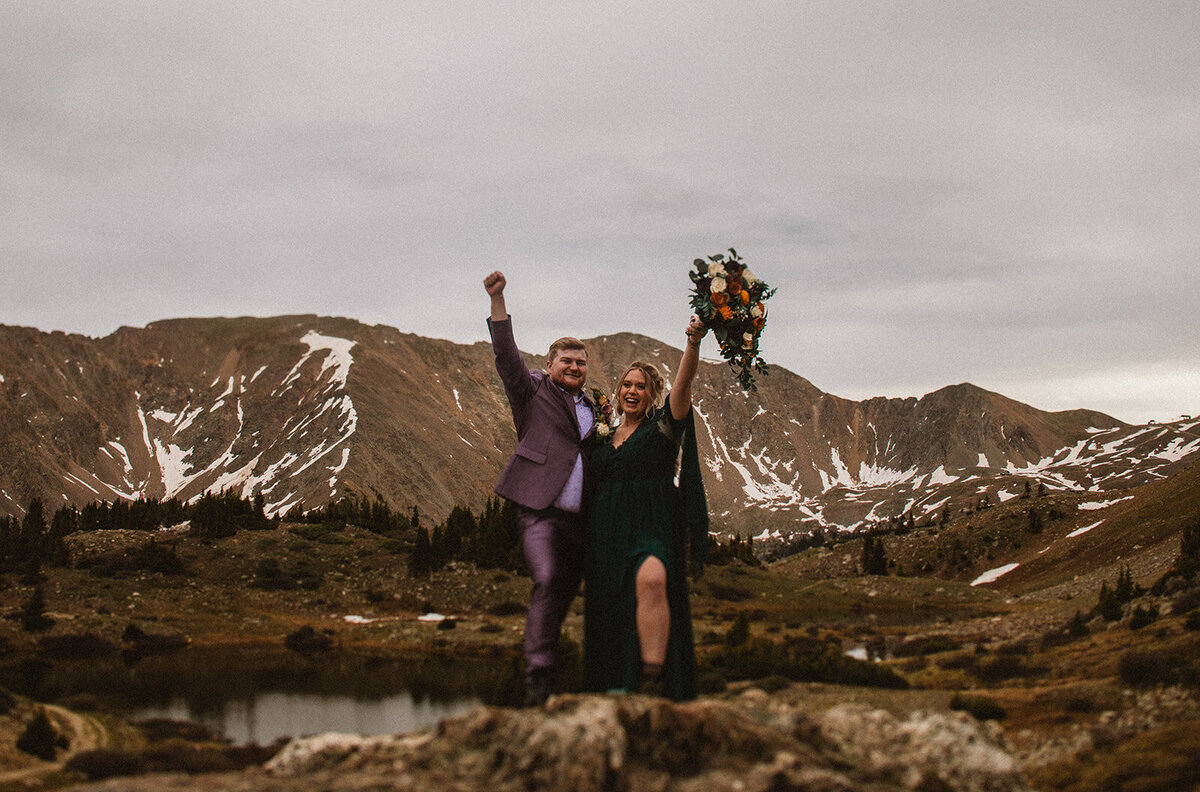 couples elopement wearing green dress and purple suit at loveland pass