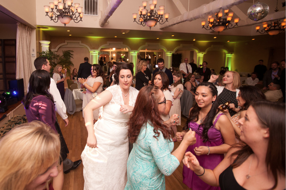 Bride with guests on packed dance floor with cool upliighting