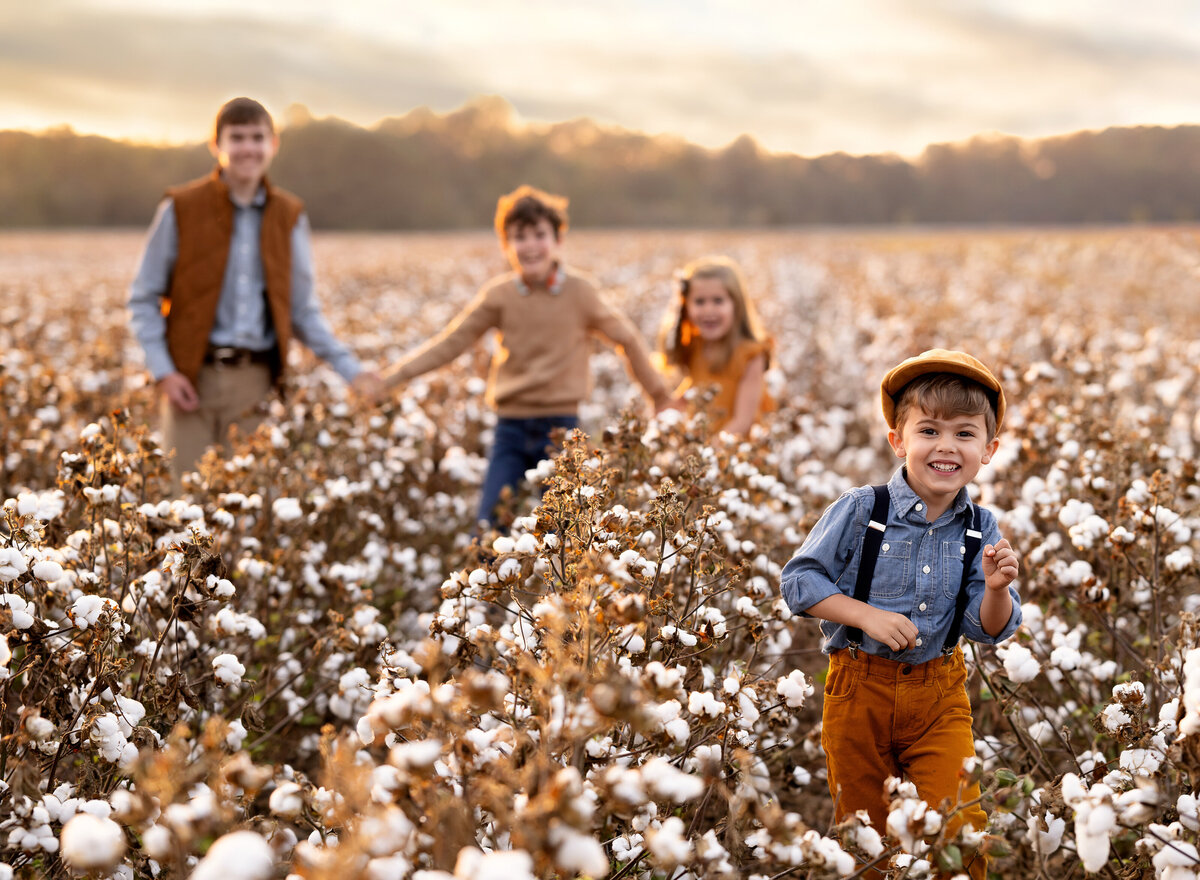 Fall photo of 4 kids running and playing in a cotton field located in Georgia.