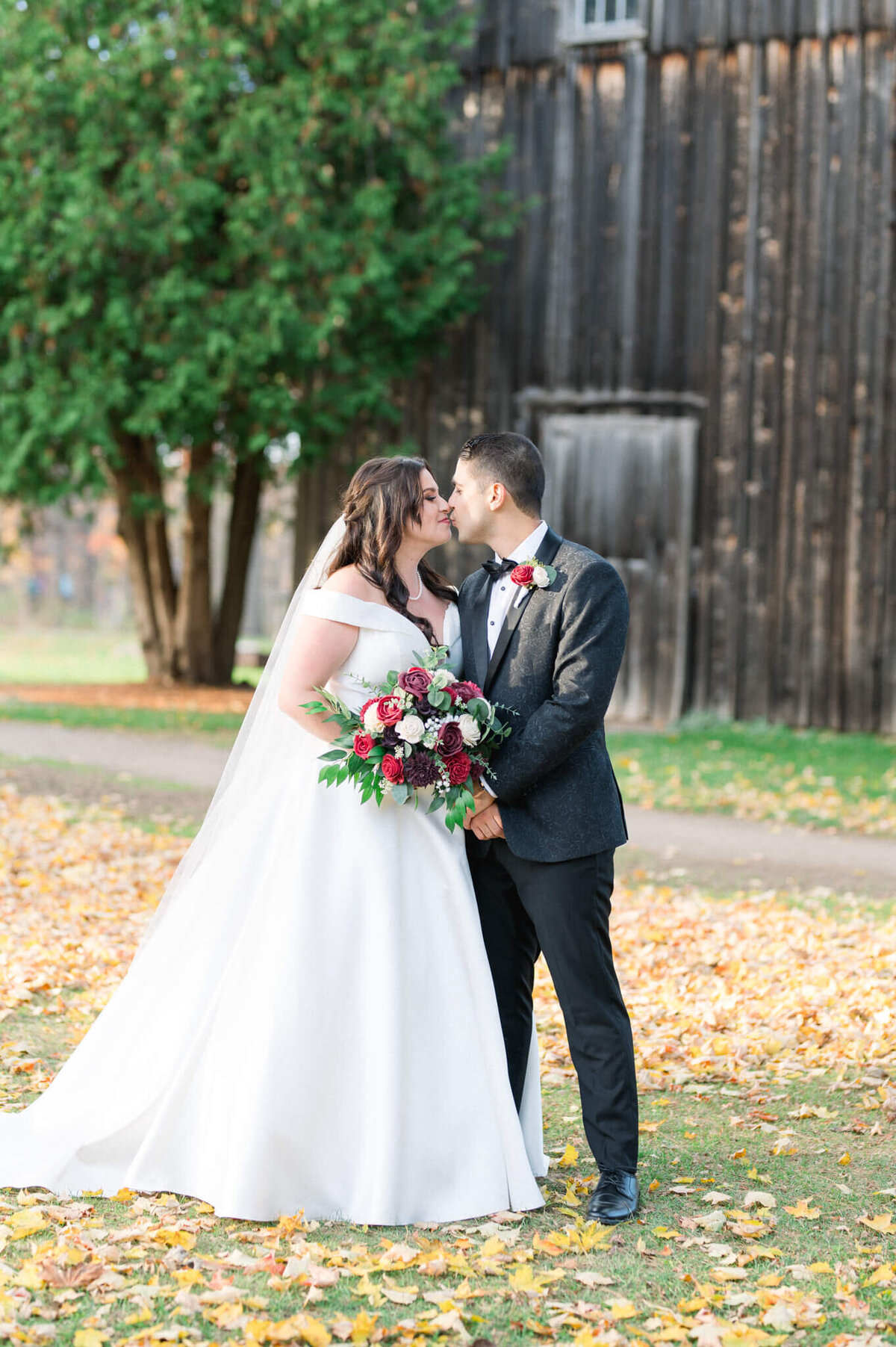 Bride and groom kiss for their wedding portrait captured by Toronto wedding photographer