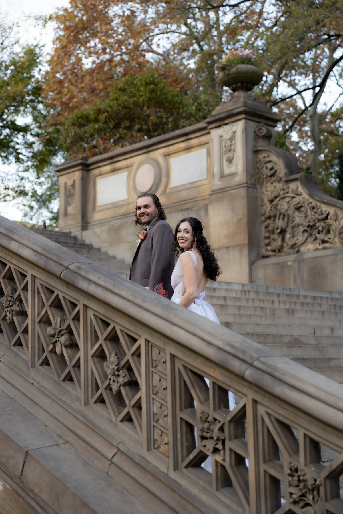 Bride and groom sharing a quiet moment under golden fall trees in Central Park.
