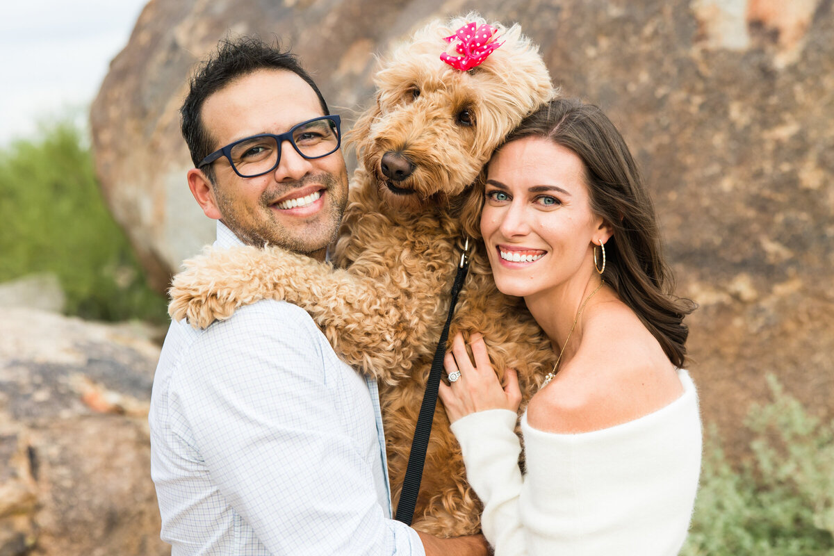 couple smiling together with their dog