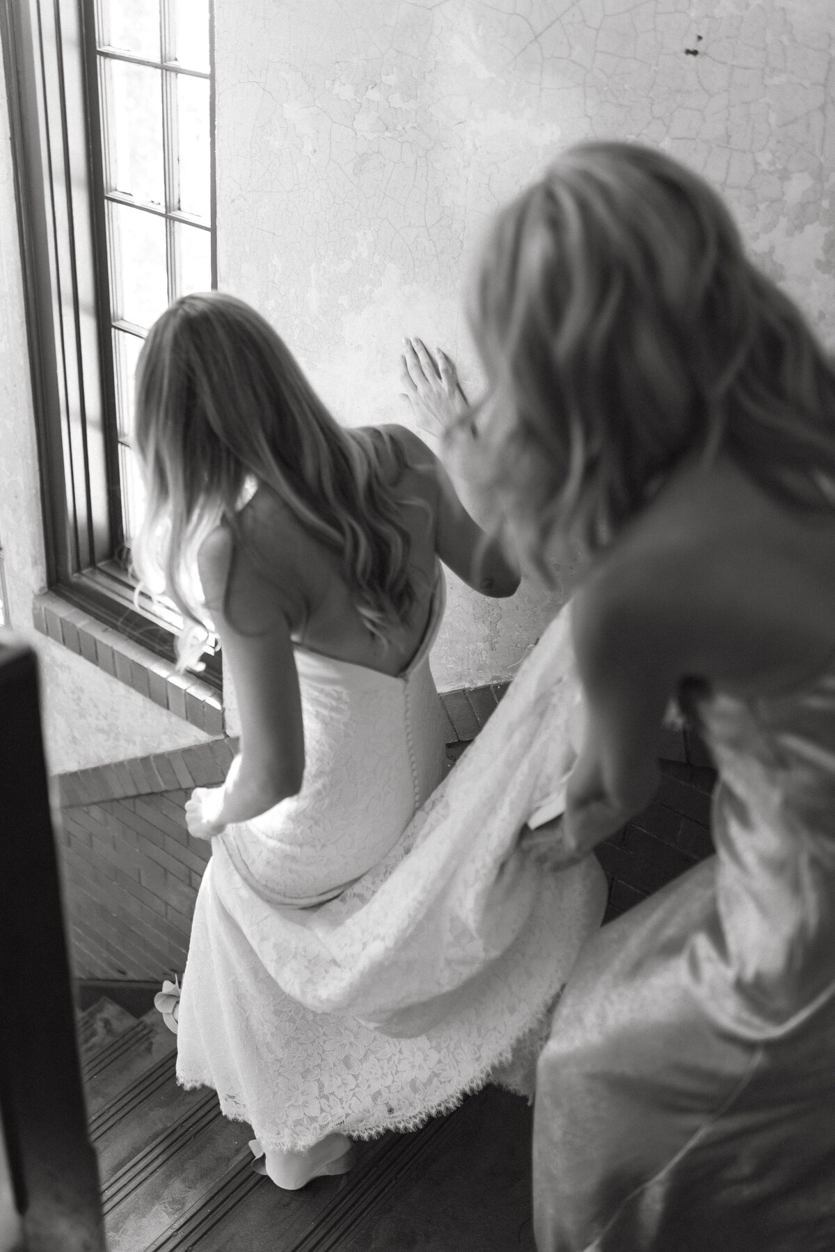 mother of bride helping bride down stairs