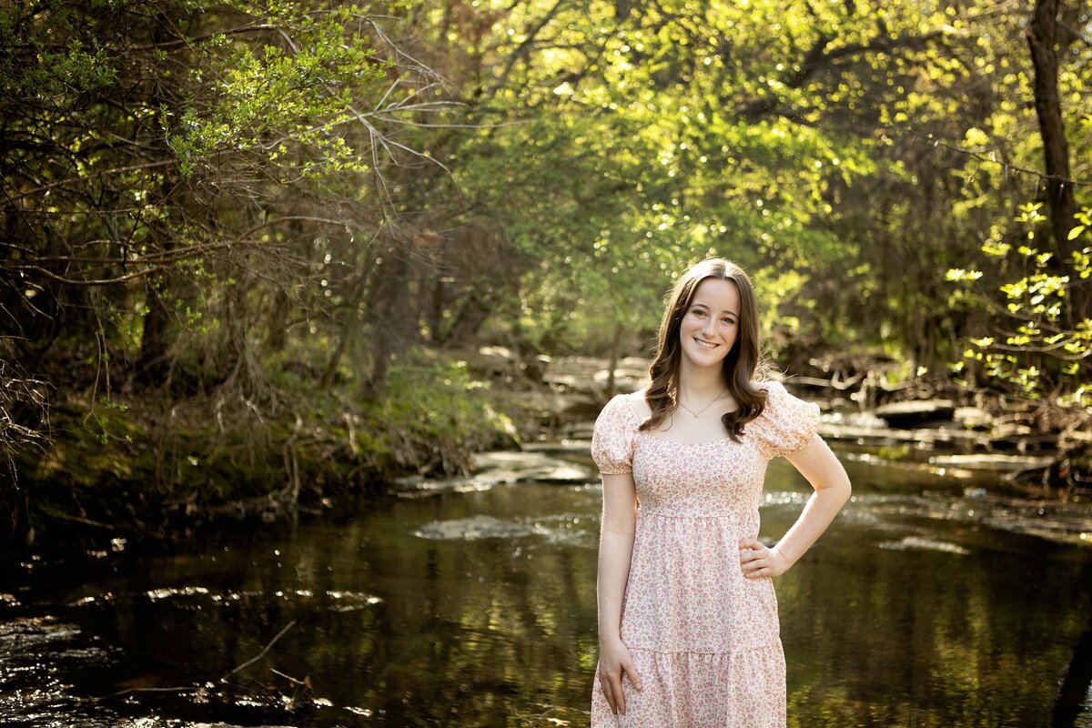 A senior poses with their hands on their hips, exuding confidence and strength