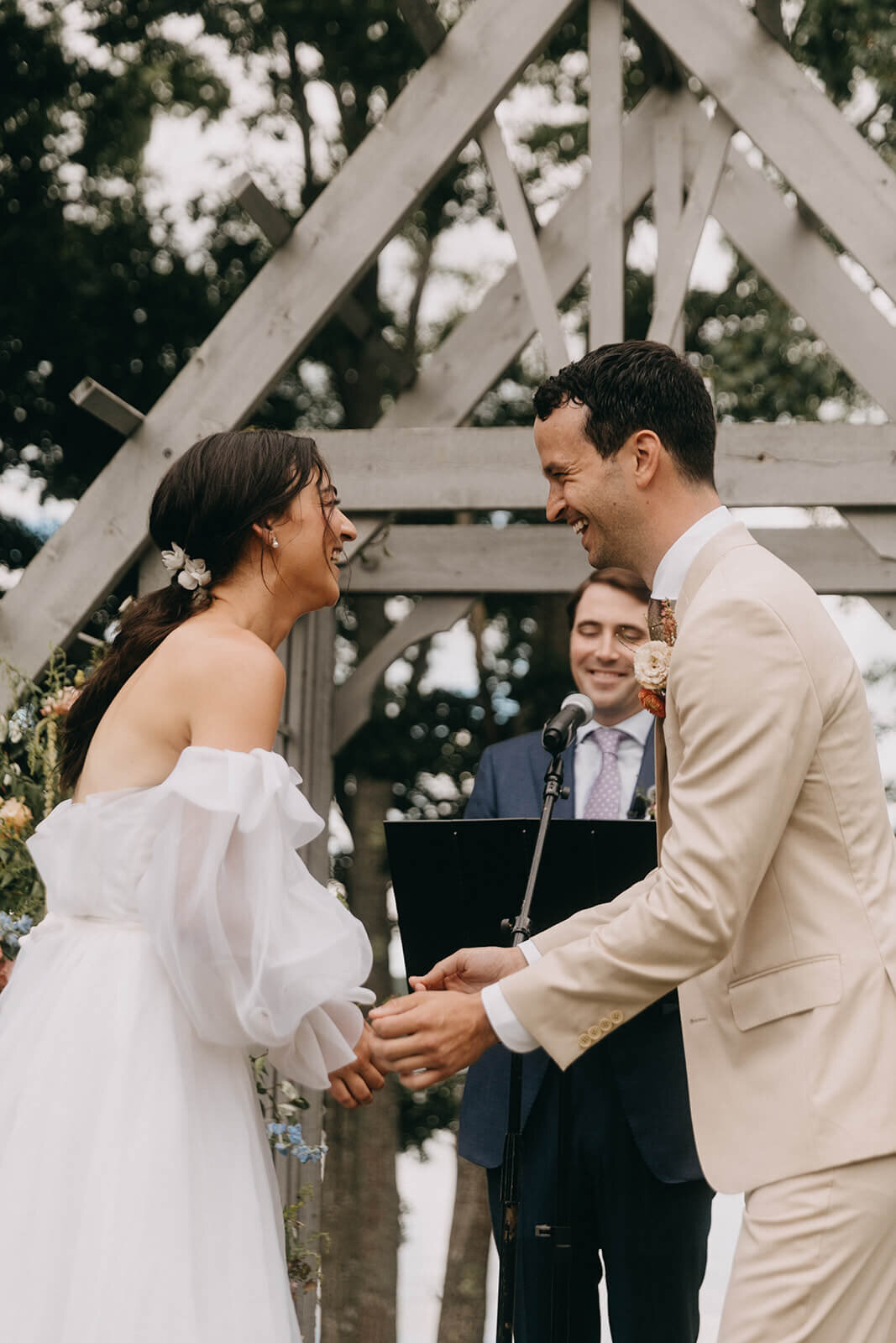 29.bride-and-groom-laughing-outdoor-wooden-arch-pastel-wedding-flowers